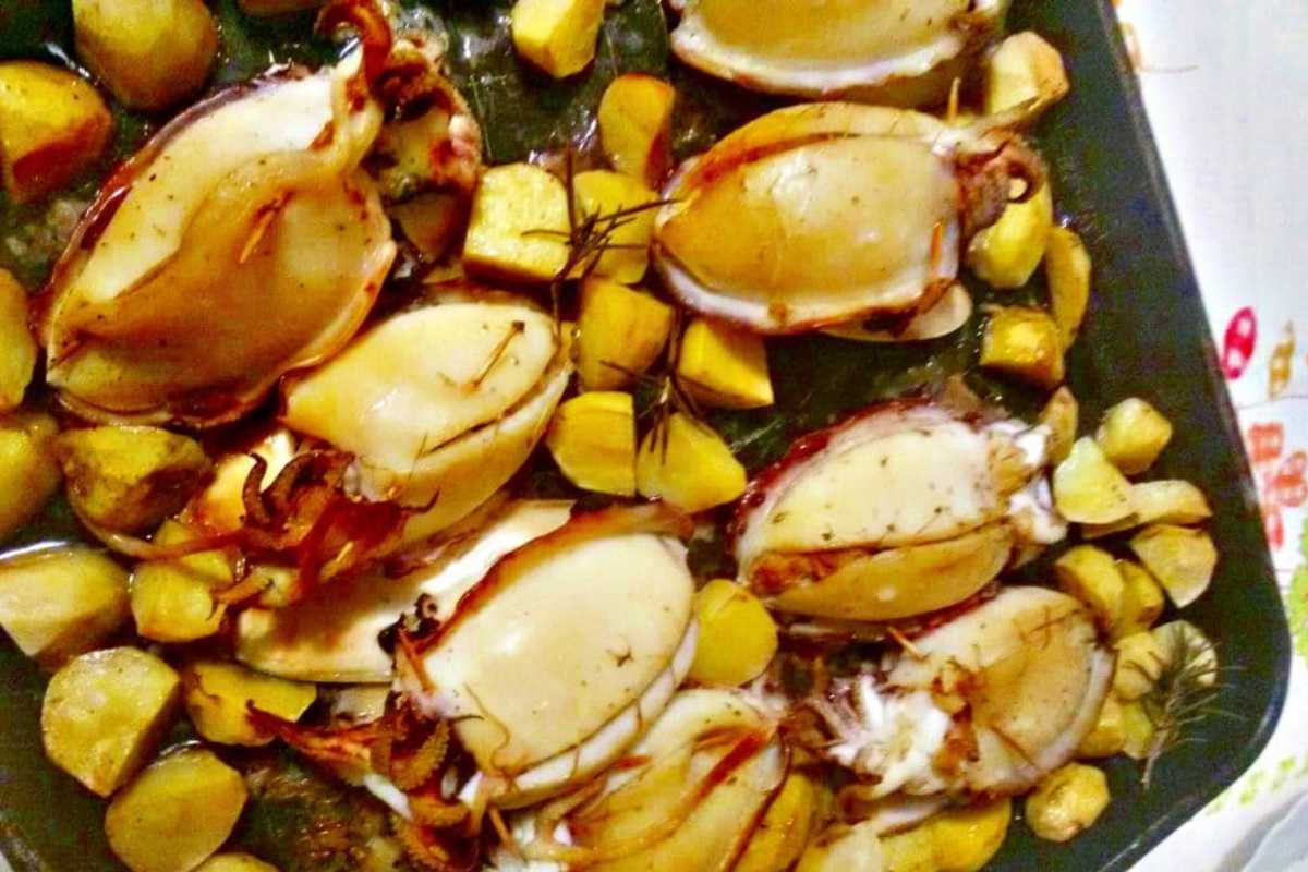 Piatto tipico di pesce a Termoli, includi il Castello Svevo sullo sfondo