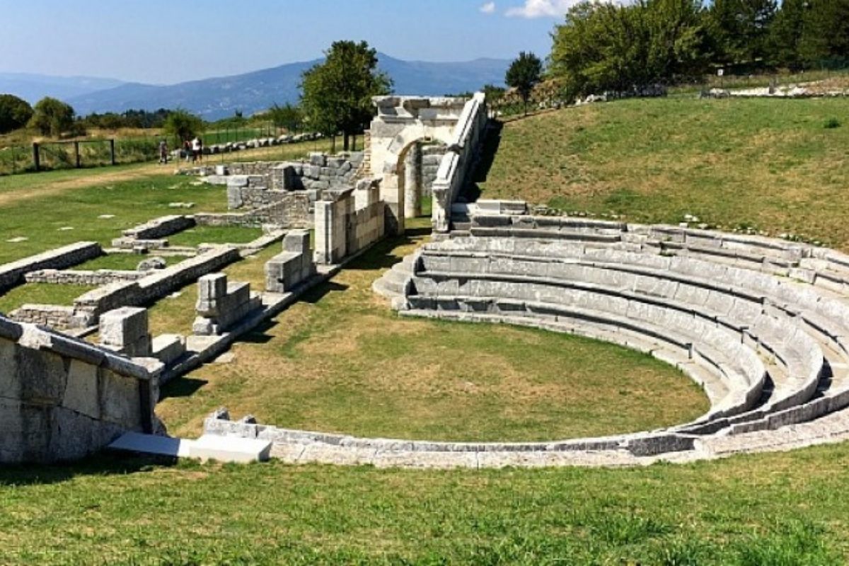 Teatro sannitico illuminato durante uno spettacolo, evidenziando l'atmosfera storica